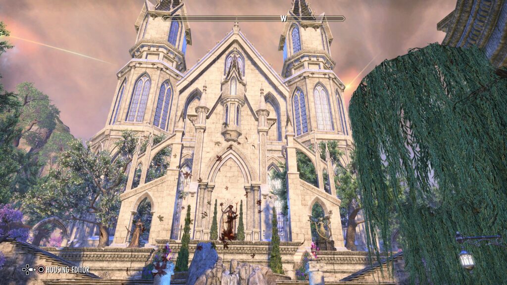 Grand Psijic Villa - Front Entrance. Statues line the arches in front of the doors. Willow tree to the side. A rock fountain sits in front of the camera.