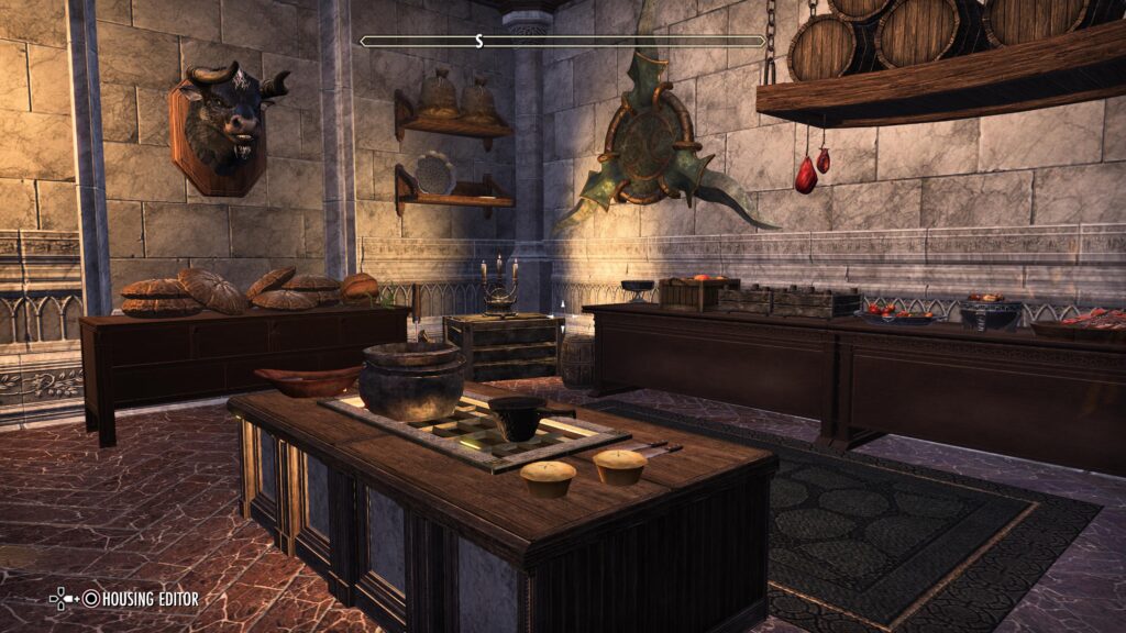Grand Psijic Villa - Kitchen. There is a grill in the center with pots and pies on it. A minotaur bust is on the wall. Tables filled with bread and fruit line the outta walls.
